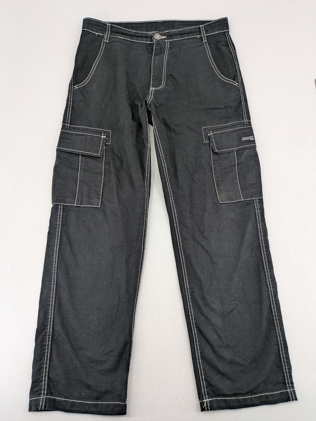 FSBN black baggy cargo pants with white contrast stitching and multiple pockets.