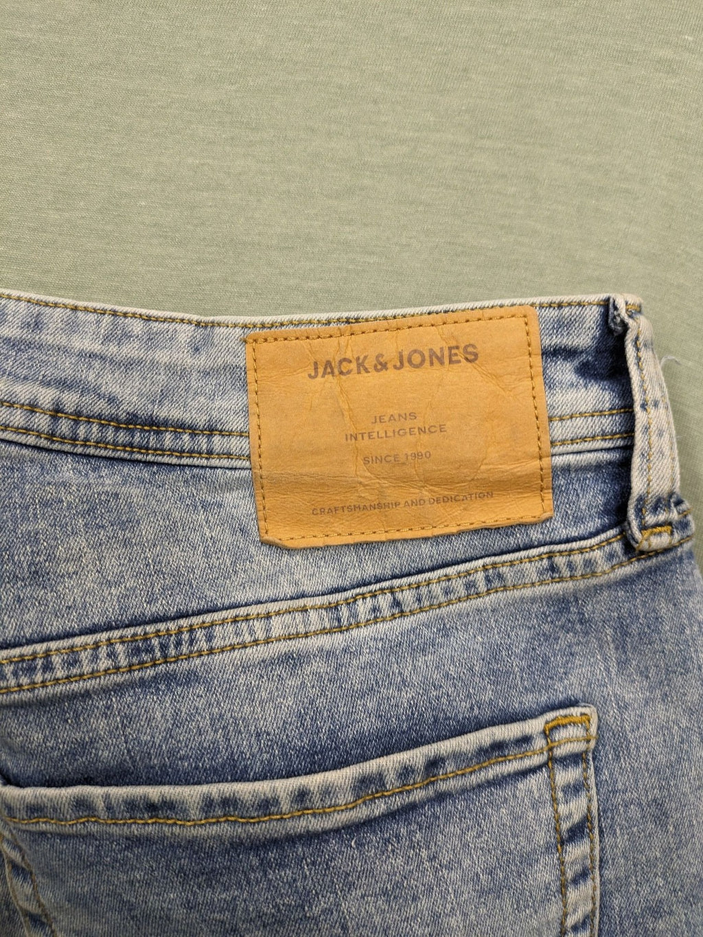 Jack & Jones blue slim fit jeans with button fly and light wash denim texture.