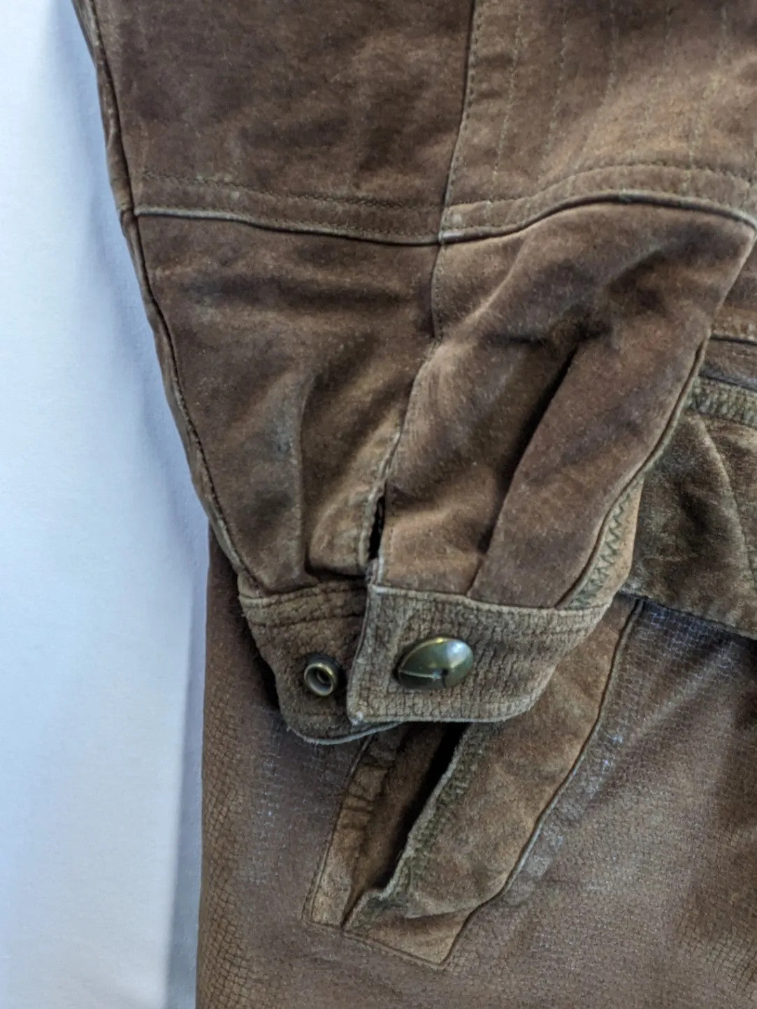 Vintage brown leather jacket with graphic lining, zip closure, and button placket.