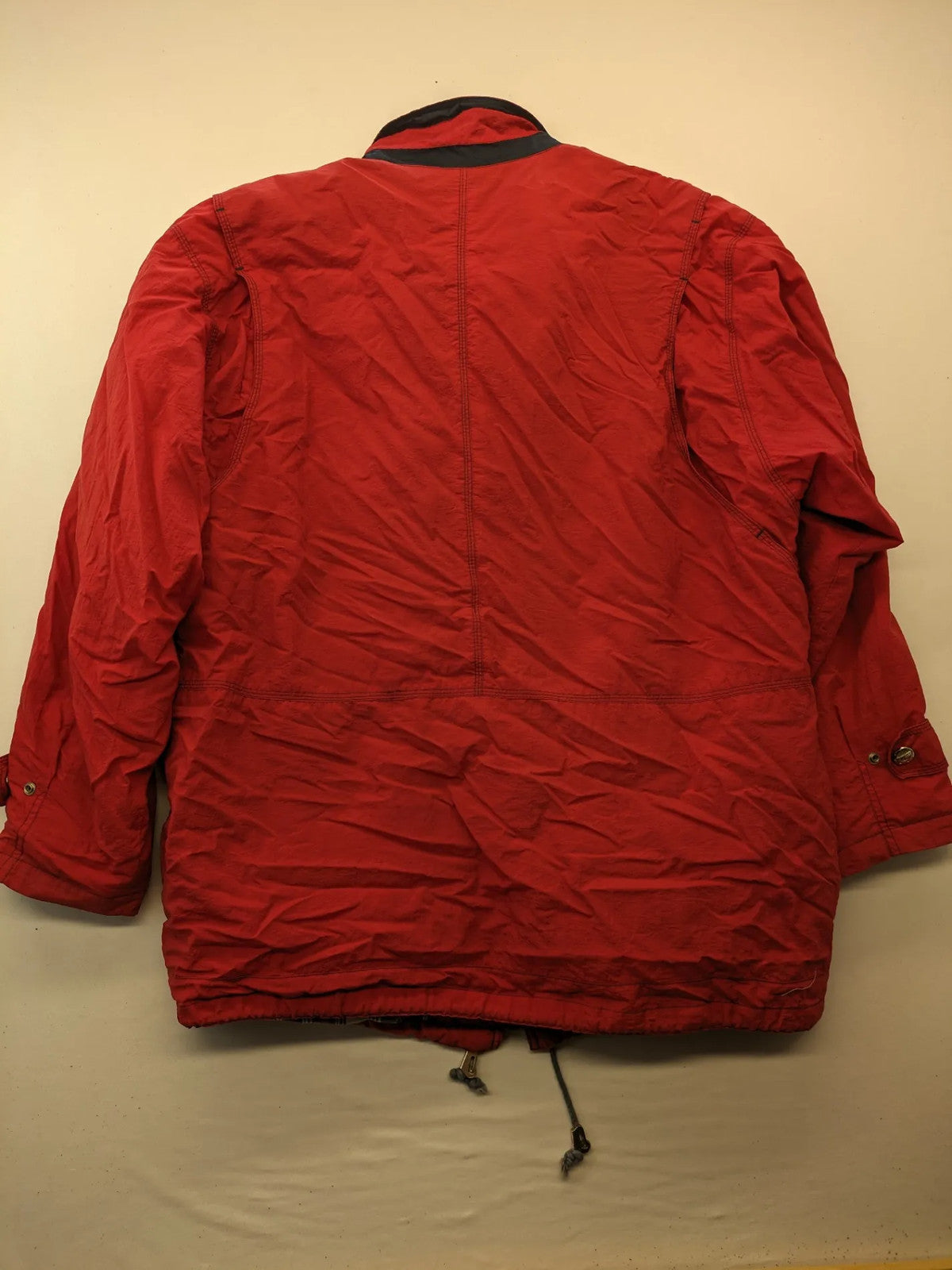Bush Sportswear red trekking jacket with front zipper, multiple pockets, and striped lining.