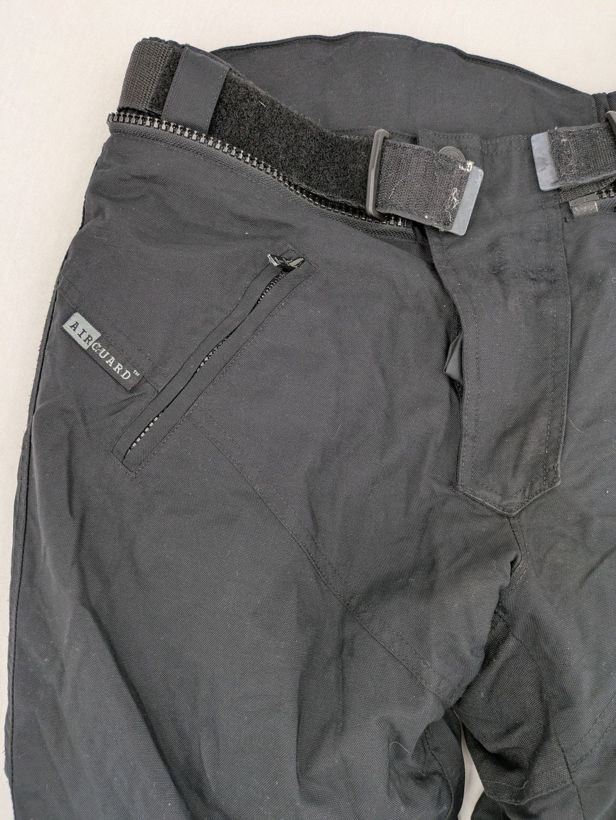 iXS black chaps with grey accents, waterproof textile, adjustable belt, reinforced knees.