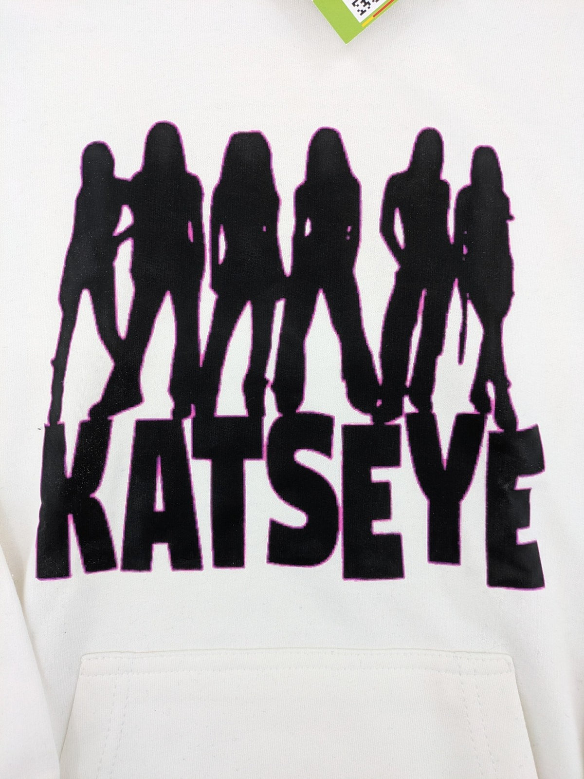 KATSEYE white zip-through hoodie with black silhouette graphic and logo, classic pullover style.