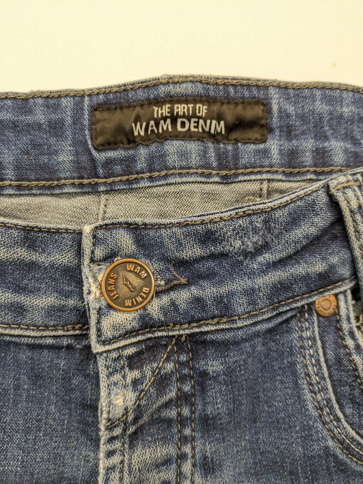 WAM Denim blue straight jeans with distressed details and button fly.
