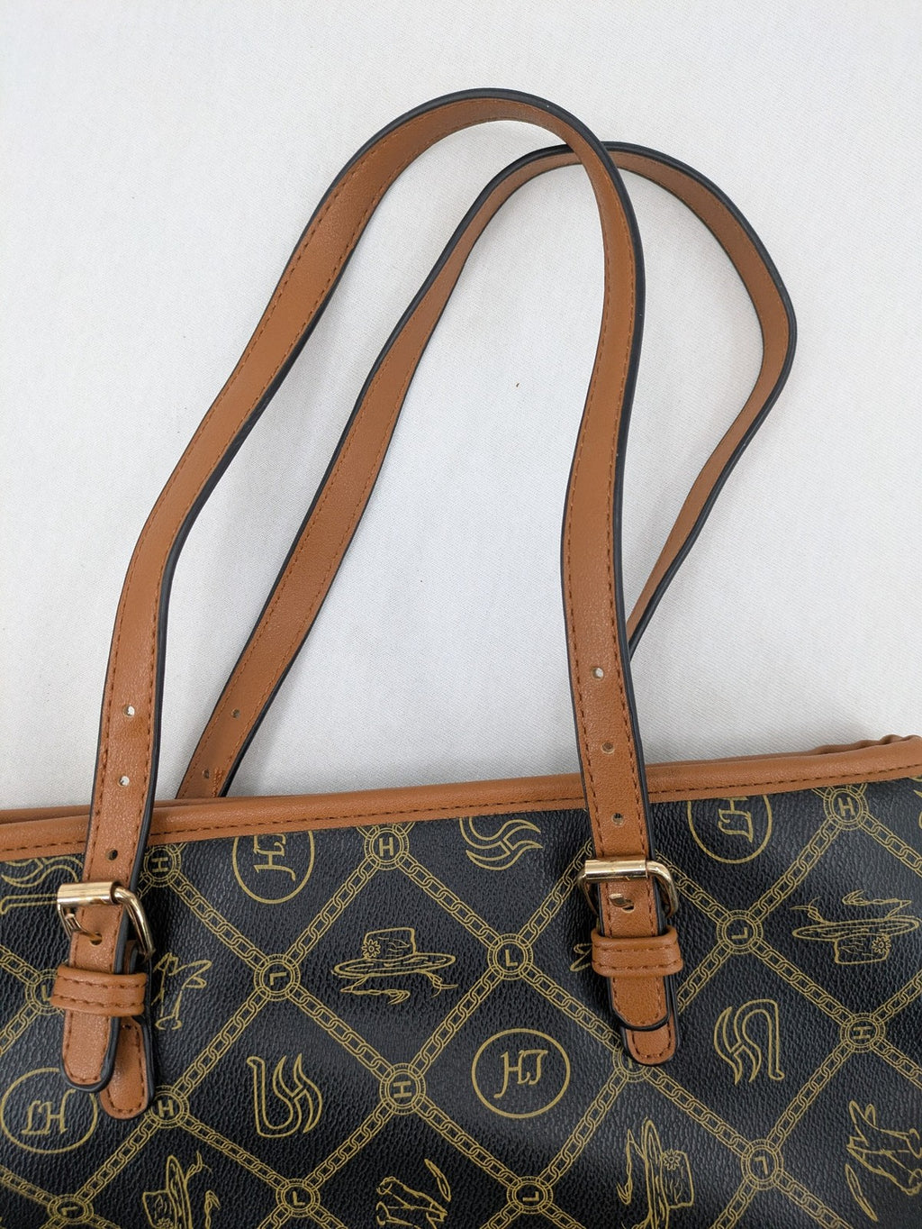 L&H brown and black handbag with monogram pattern and gold accents, versatile shoulder strap.