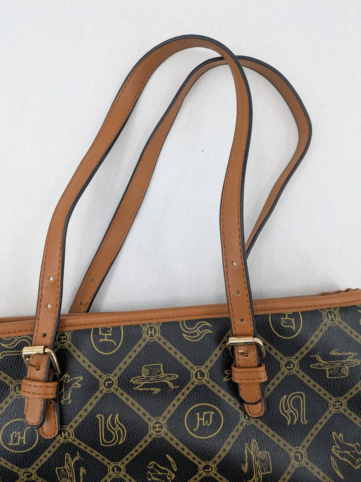 L&H brown and black handbag with monogram pattern and gold accents, versatile shoulder strap.