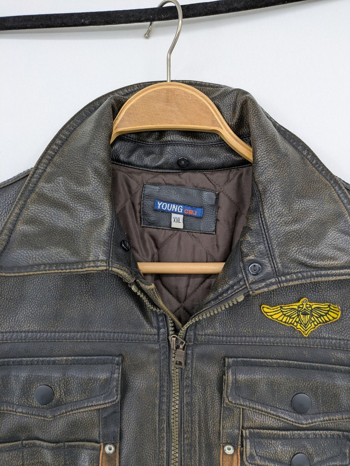 Junge brown bomber jacket with vintage patches and embroidered details in faux leather.