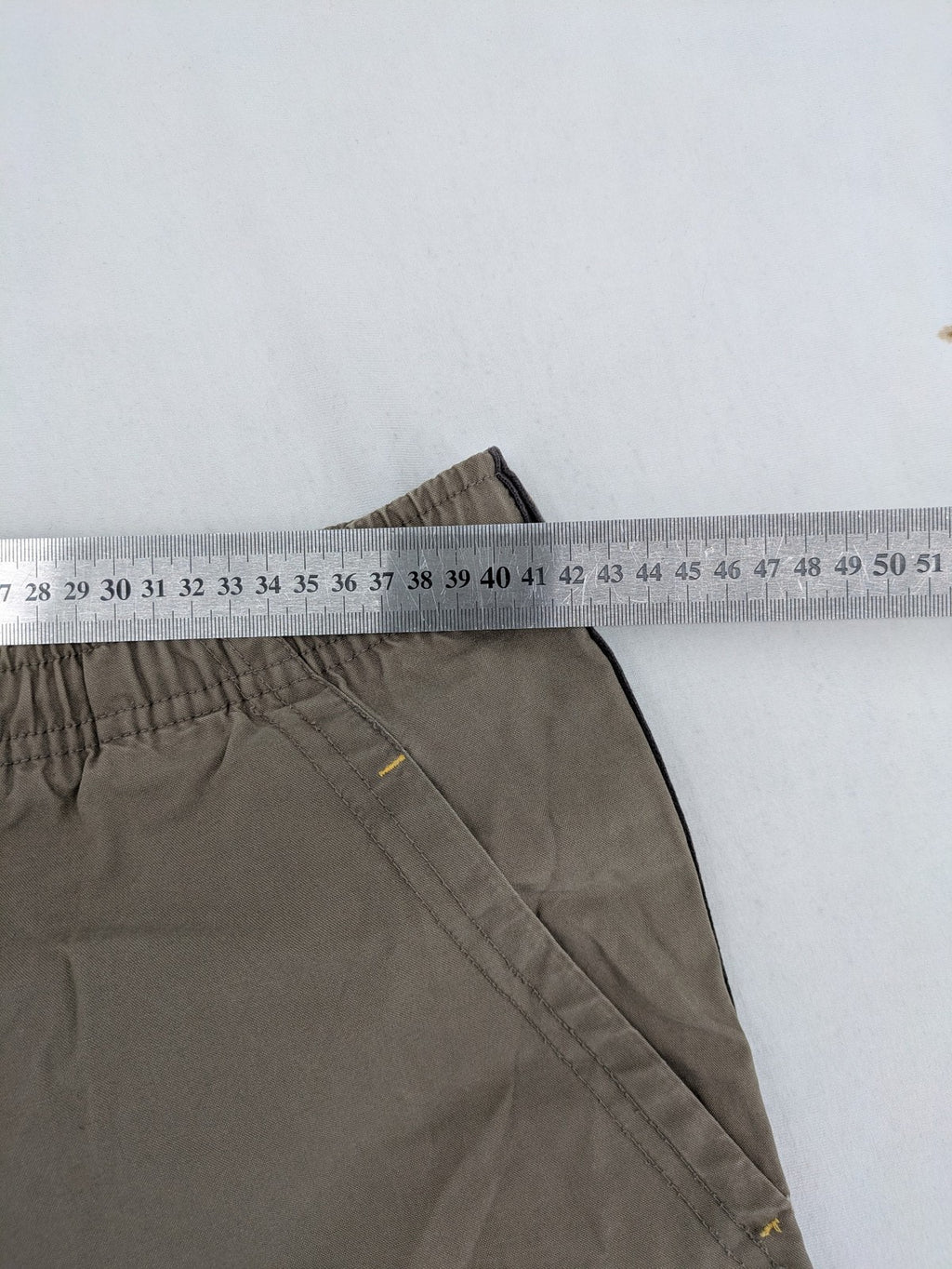 Nike khaki training pants with logo, elastic waistband, and practical pockets.