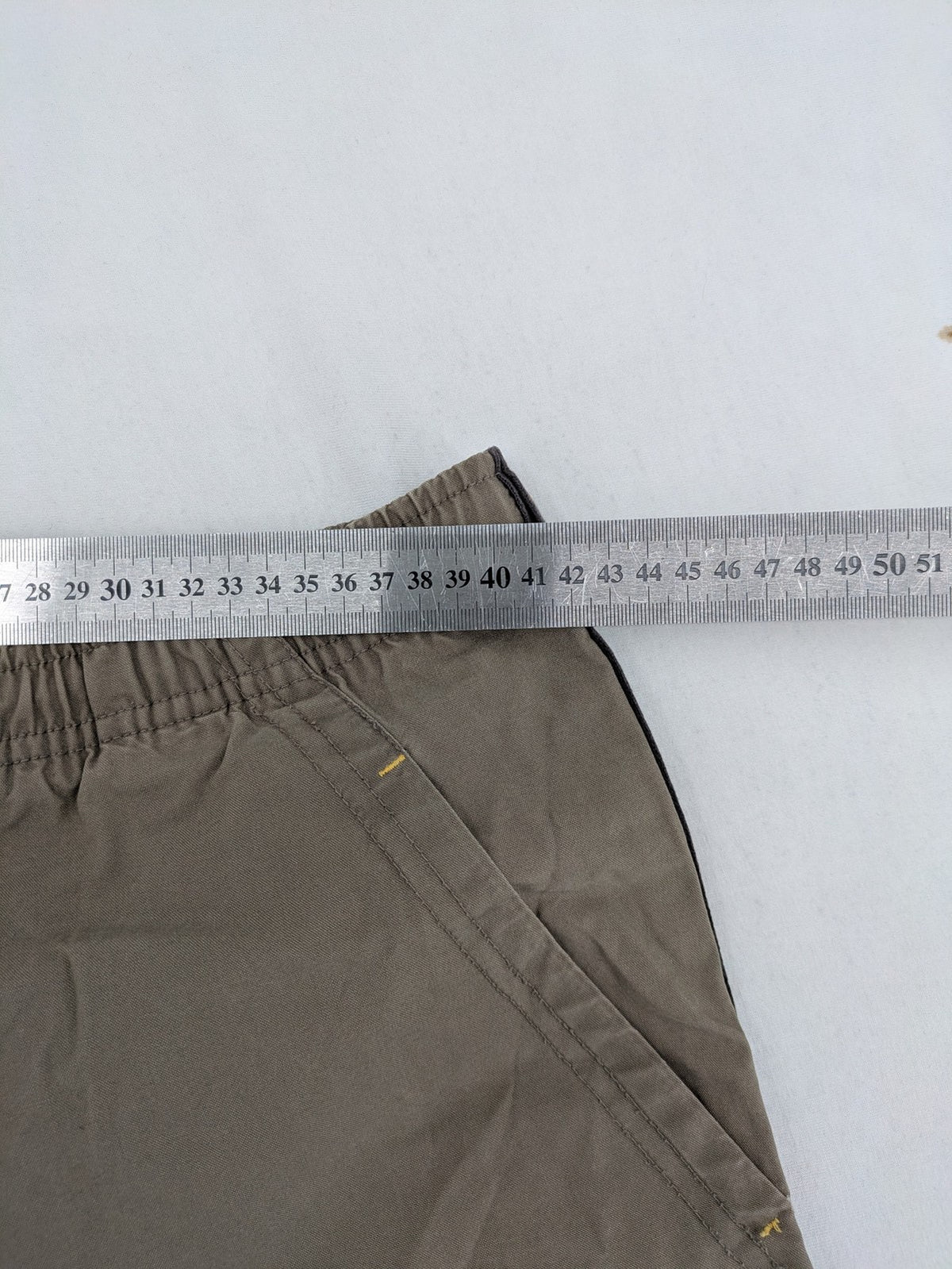 Nike khaki training pants with logo, elastic waistband, and practical pockets.