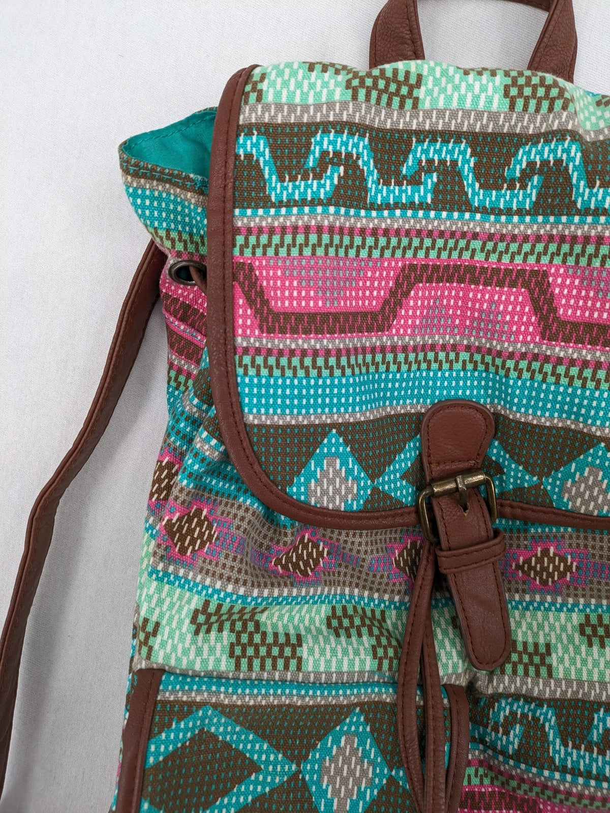 Boho multi backpack with vibrant Aztec tribal print and brown faux leather accents.