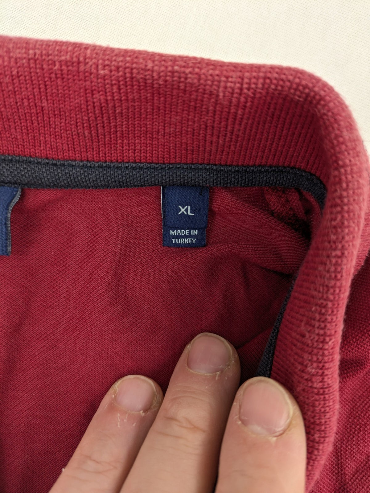 GANT burgundy polo shirt with embroidered shield logo and contrasting navy collar details.