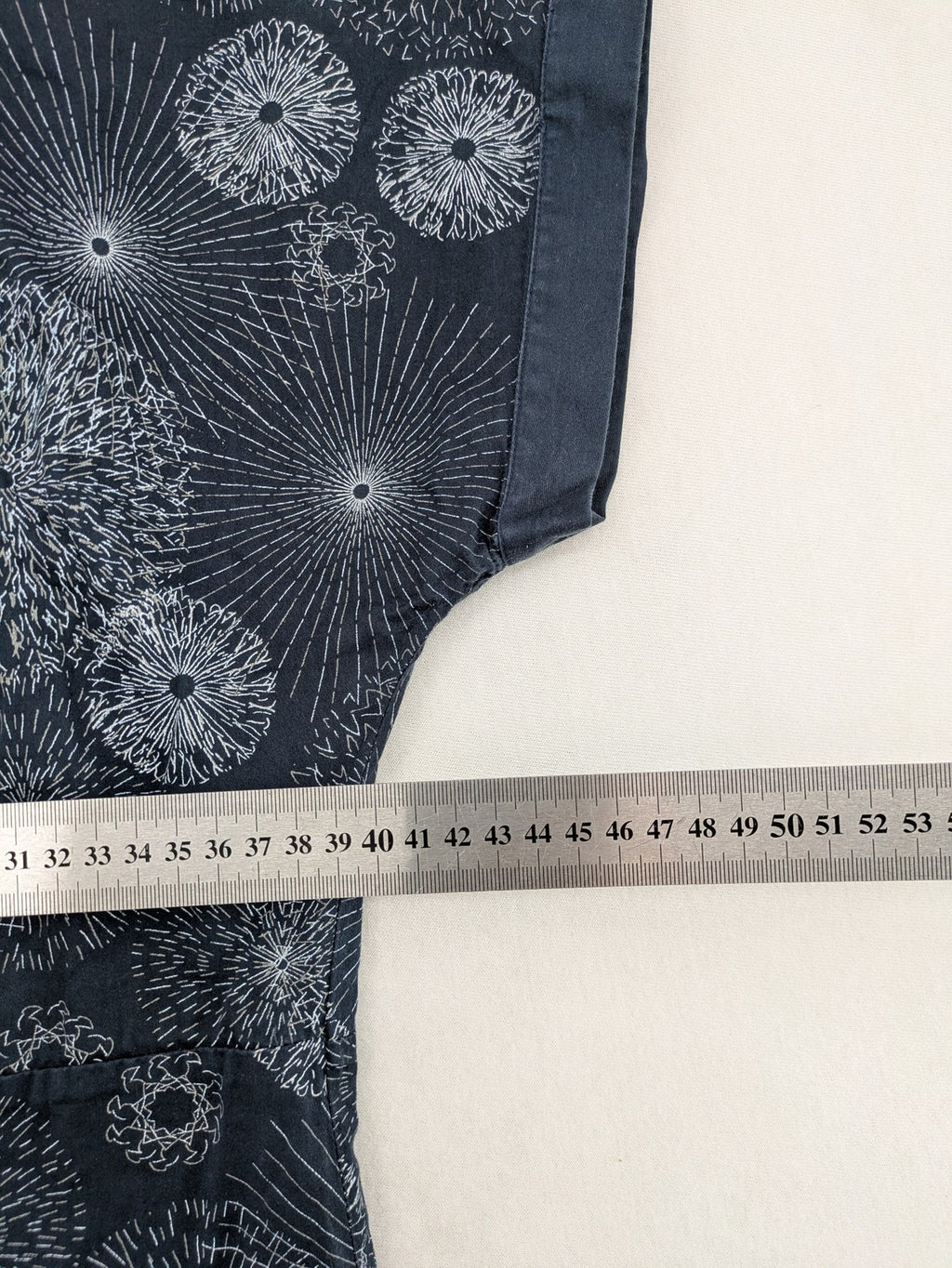 Muster navy dress with white abstract dandelion print, V-neck and collar details.