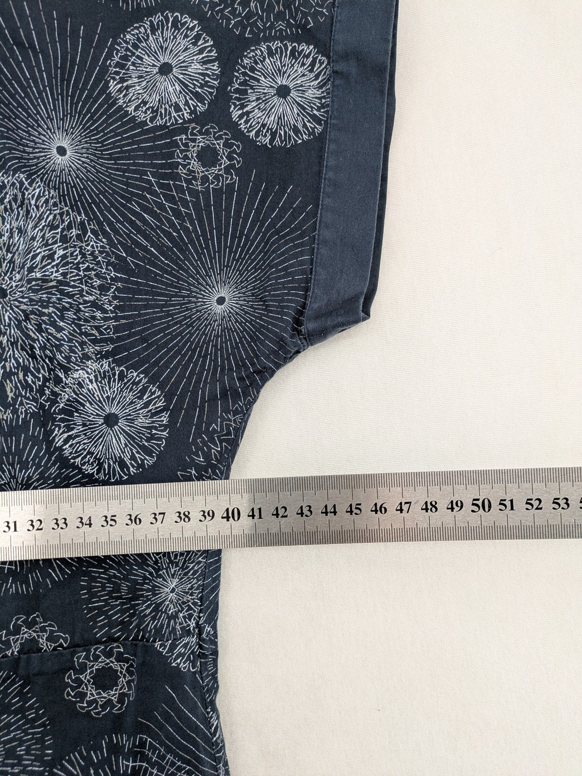 Muster navy dress with white abstract dandelion print, V-neck and collar details.