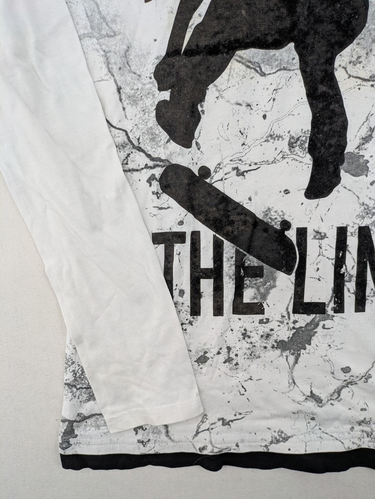 Chapter Young long sleeve shirt white with black skateboarder graphic and motivational text.