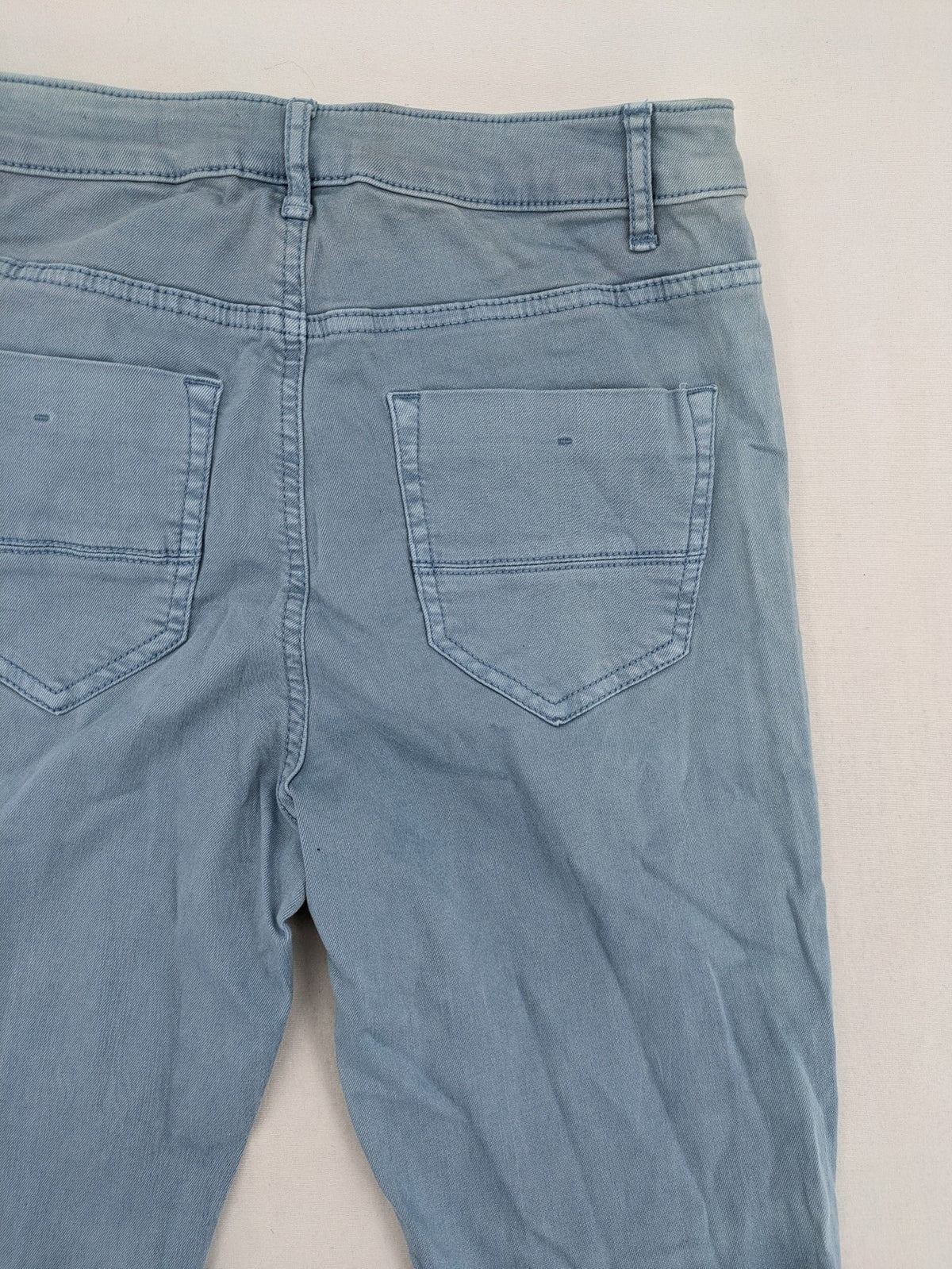 Yessica blue skinny jeans high rise with button fly and V-cut hem detail.