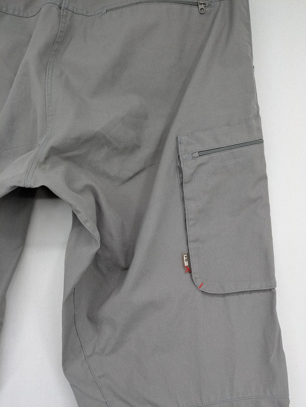 YETI grey cargo pants with multiple zippered pockets and durable material.