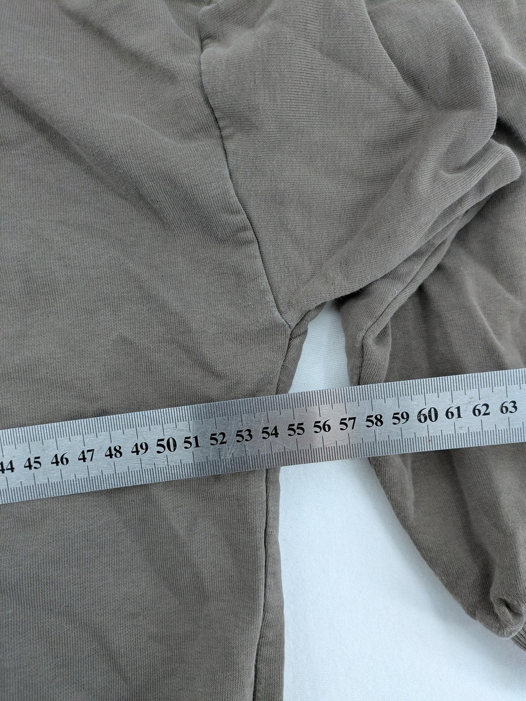 Mosquito grey hoodie with distressed cuffs and subtle logo on the chest.