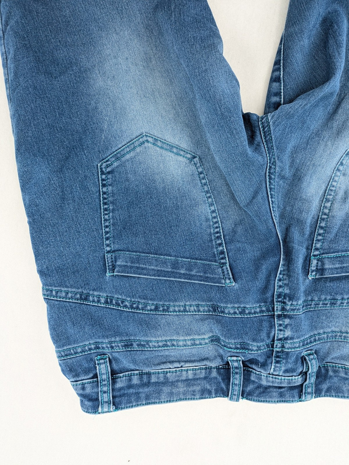 Rainbow blue straight jeans jogger style with button fly and contrasting turquoise stitching.