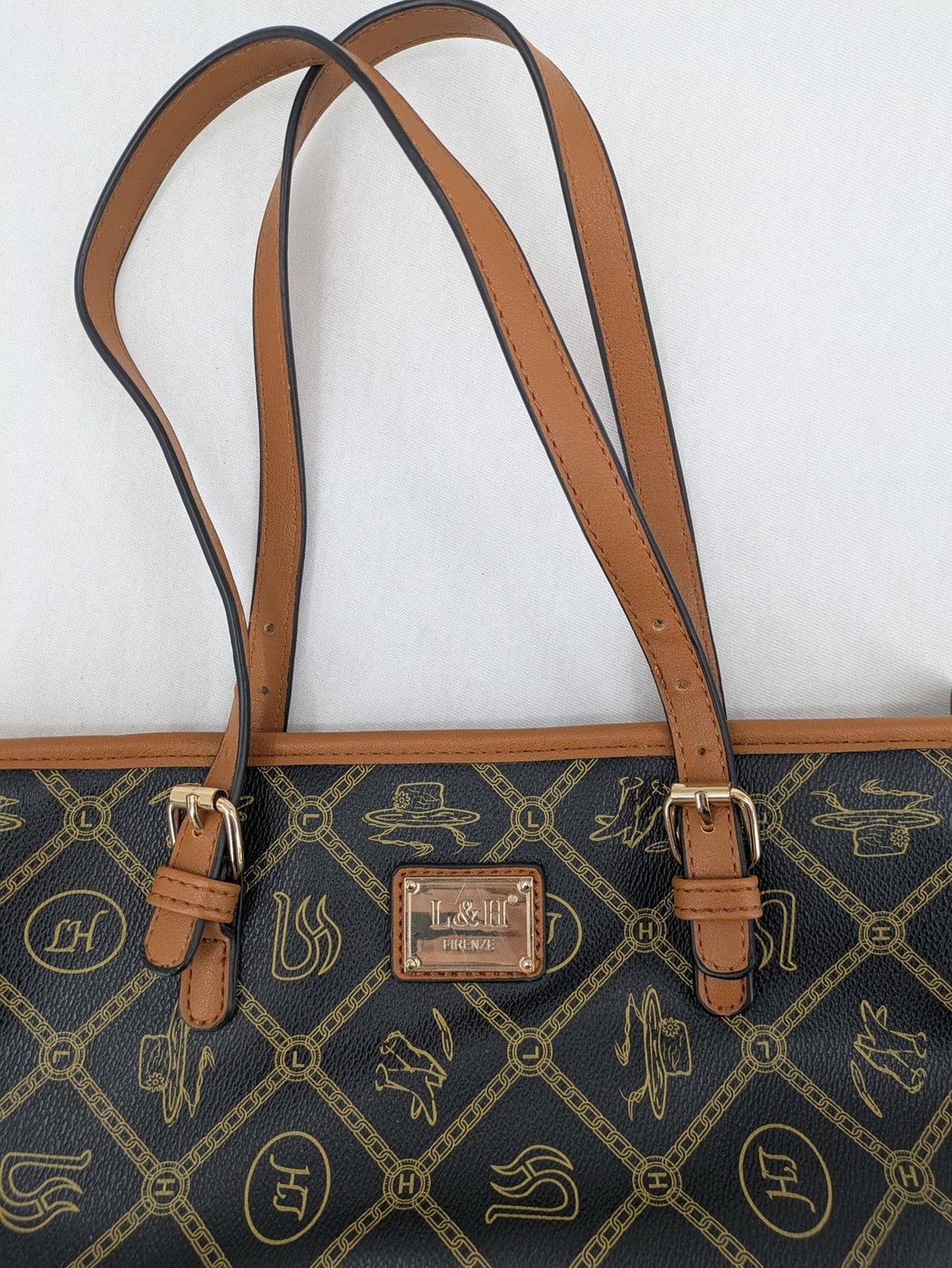 L&H brown and black handbag with monogram pattern and gold accents, versatile shoulder strap.