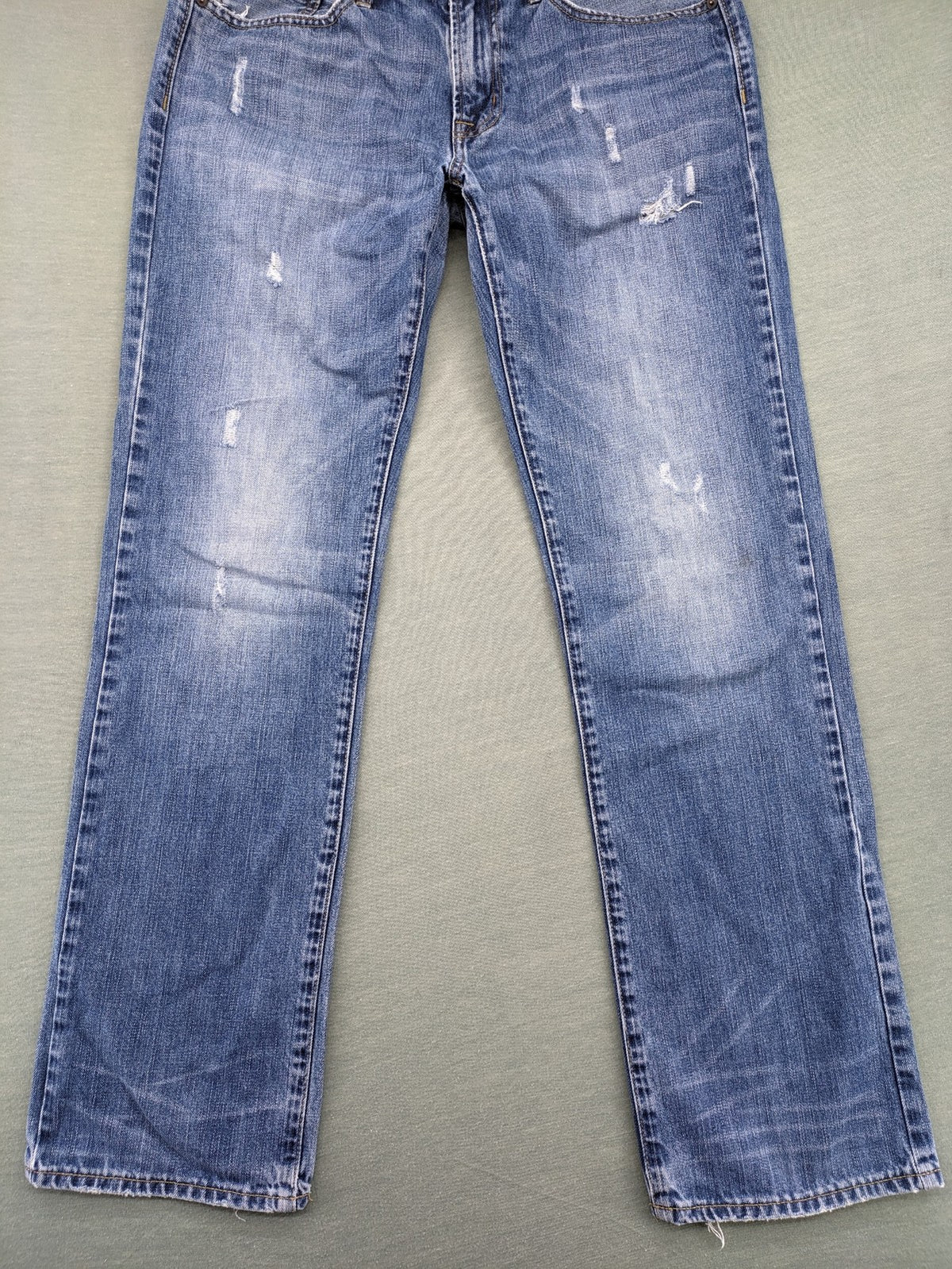 American Eagle Outfitters blue straight jeans with distressed detailing and classic five-pocket design.