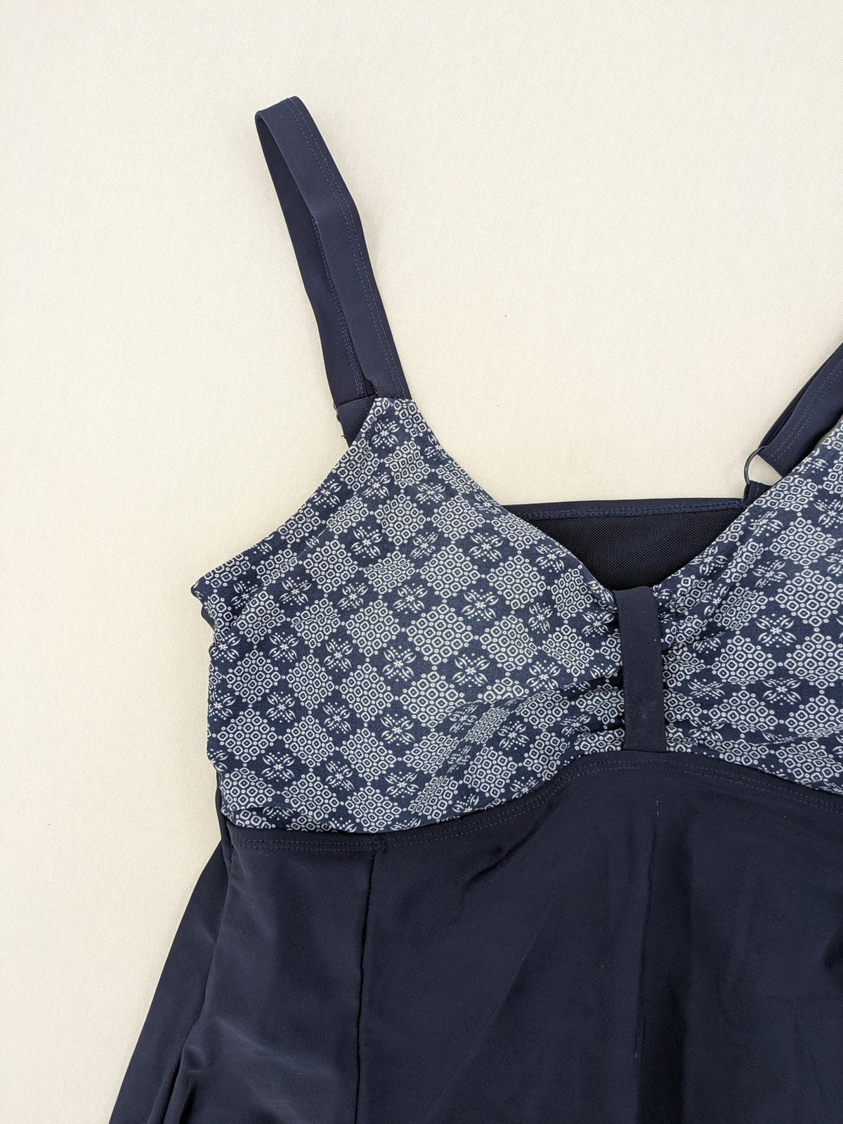 Muster blue one-piece swimsuit with geometric pattern and adjustable straps.