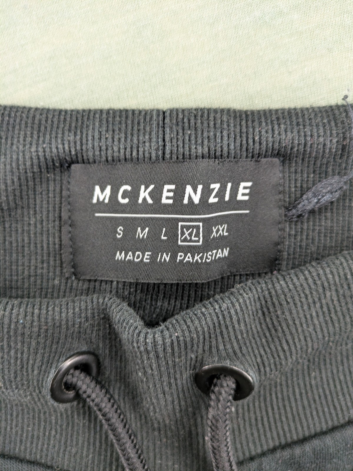 McKenzie black joggers with white logo, tapered fit, and ribbed ankle cuffs.