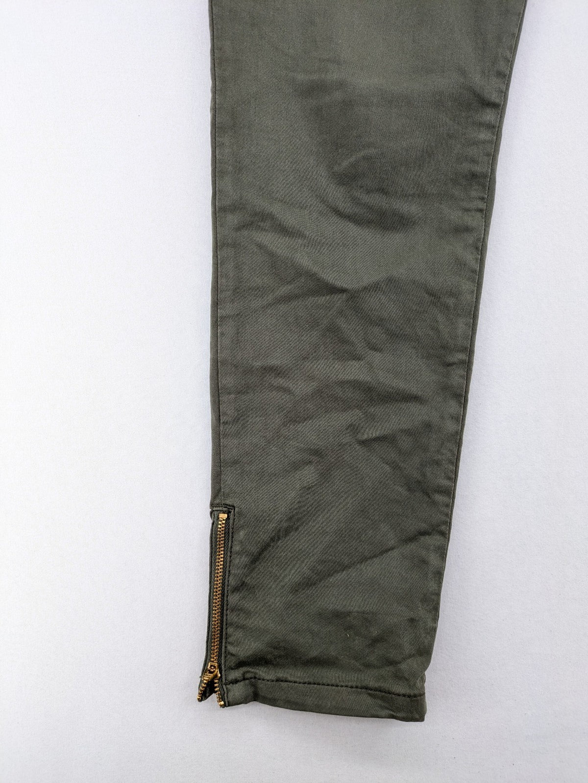 Maison 123 green cargo pants with ankle zippers and gold metal details.