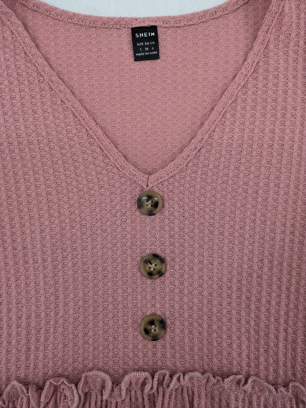 SHEIN pink top V-neck with ruffled waist and three decorative buttons, waffle knit fabric.