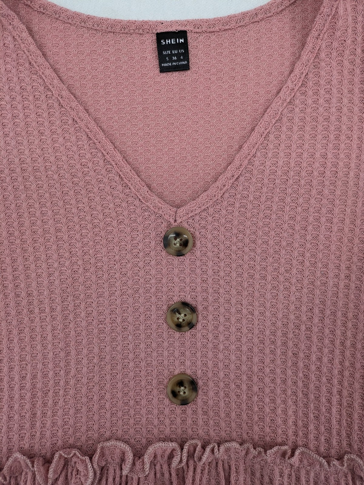 SHEIN pink top V-neck with ruffled waist and three decorative buttons, waffle knit fabric.