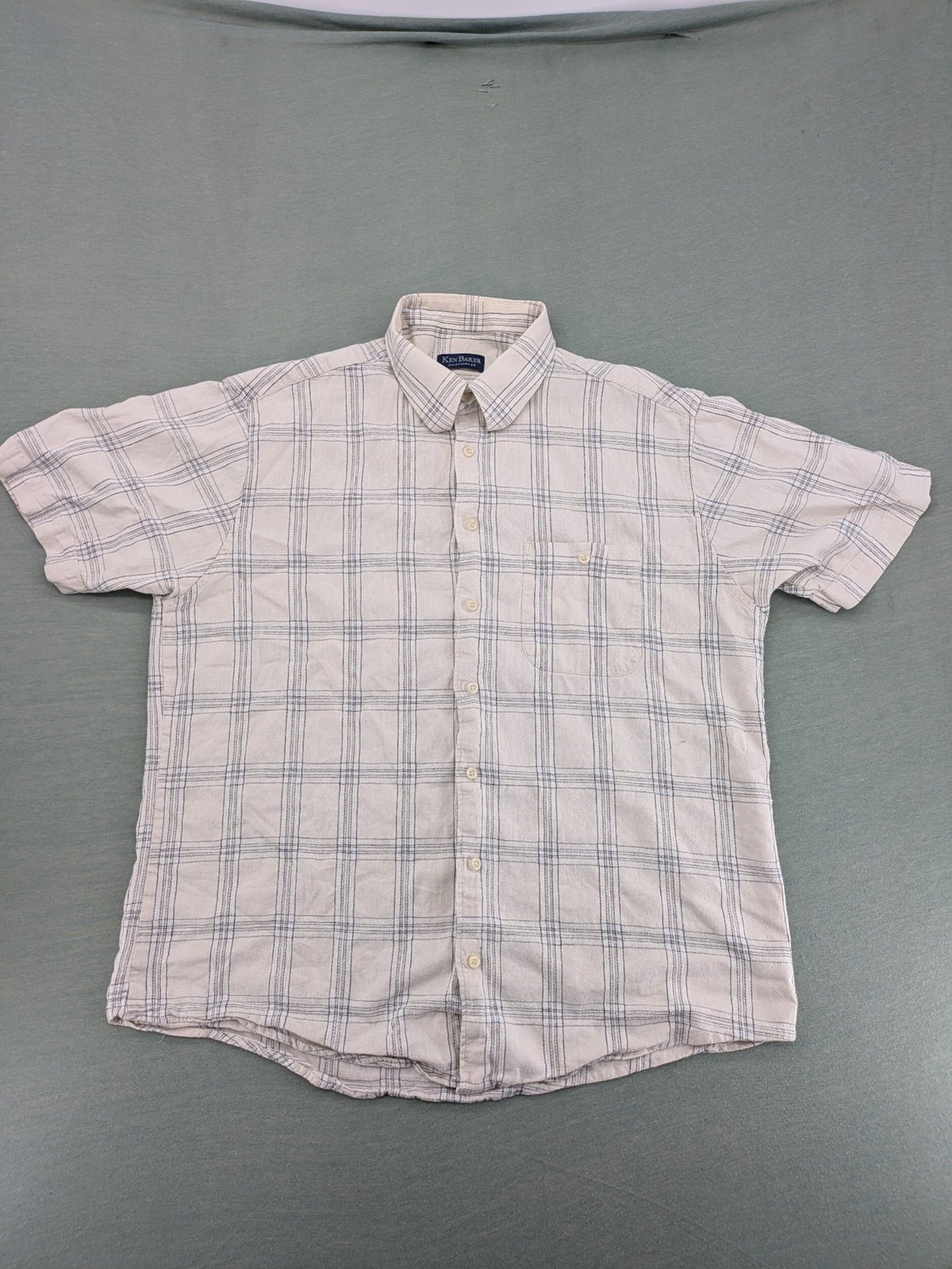 Ken Baker short-sleeve button-down shirt beige blue check pattern with single chest pocket.