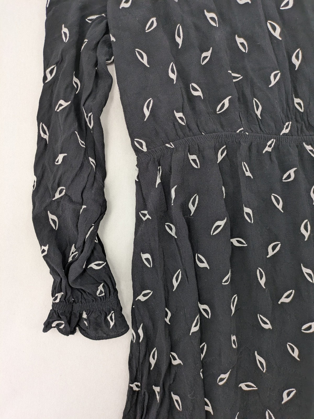 H&M grey and white dress with leaf print, V-neck, long sleeves, elastic cuffs.