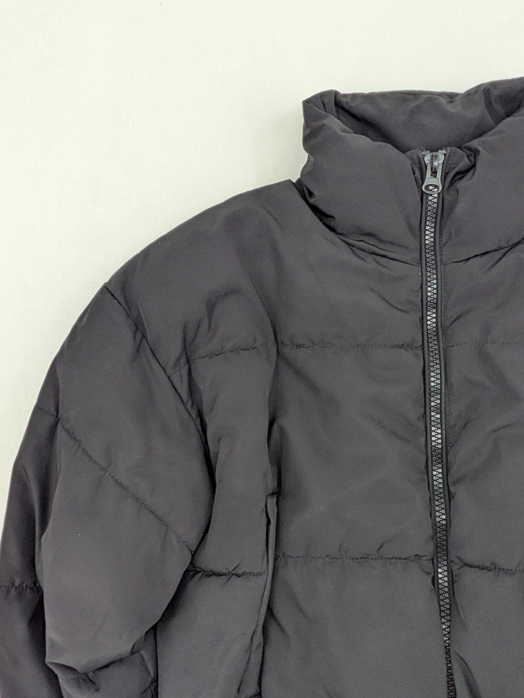 H&M Divided black cropped puffer jacket with zip closure and high collar.