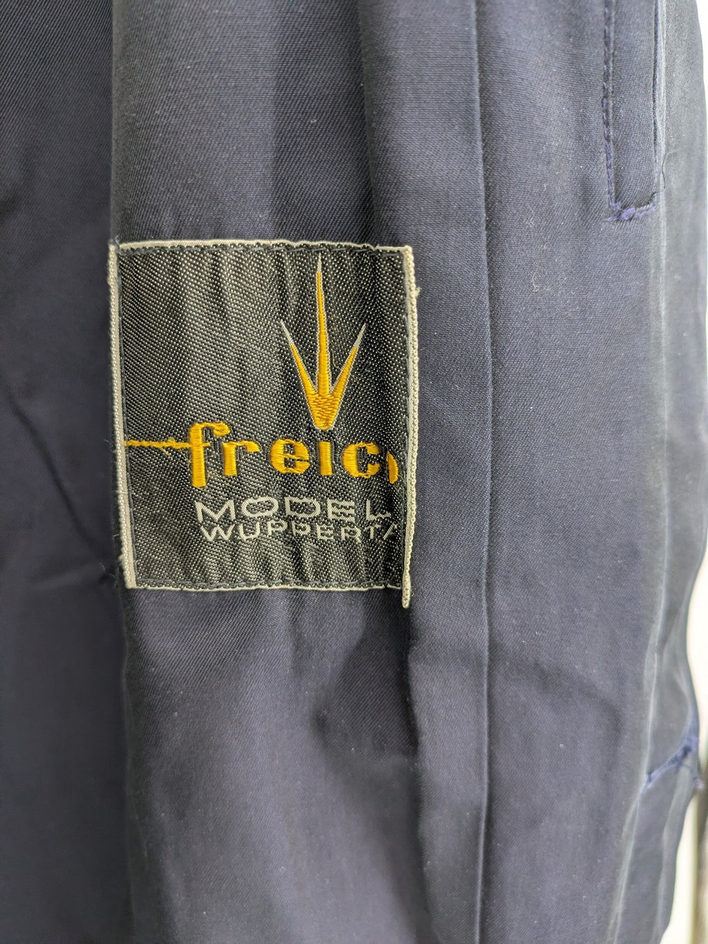 Freic navy trench coat single-breasted design with elegant collar and buttoned flap pockets.