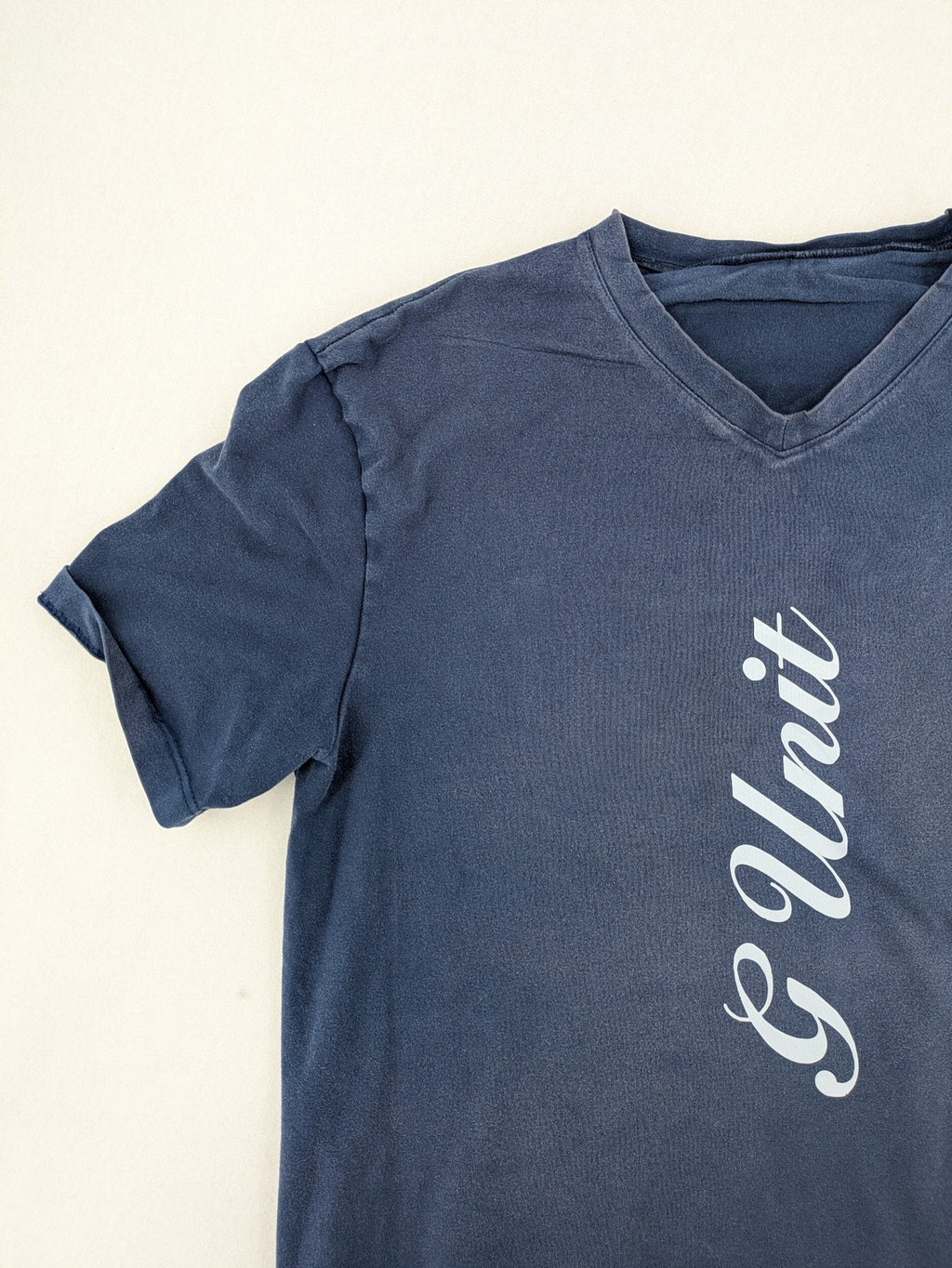 G-Unit navy vintage T-shirt with vertical logo print and V-neck design.