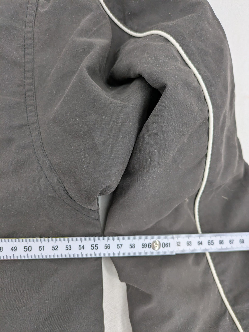Tombo green windbreaker jacket with white piping, V-neck, and zippered pockets.