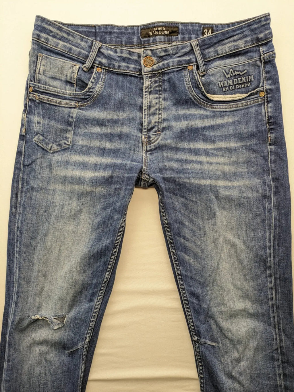 WAM Denim blue straight jeans with distressed details and button fly.