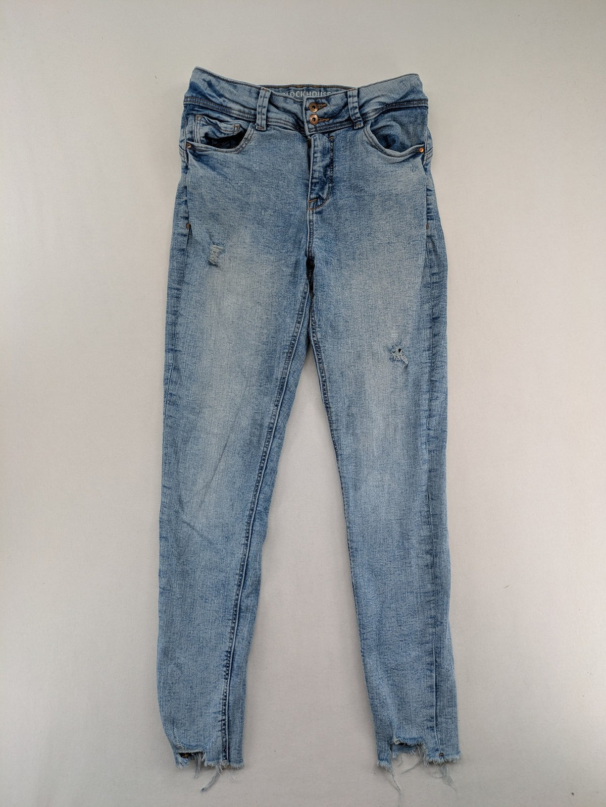 Clockhouse blue skinny jeans with distressed details and frayed hem, mid-rise fit.