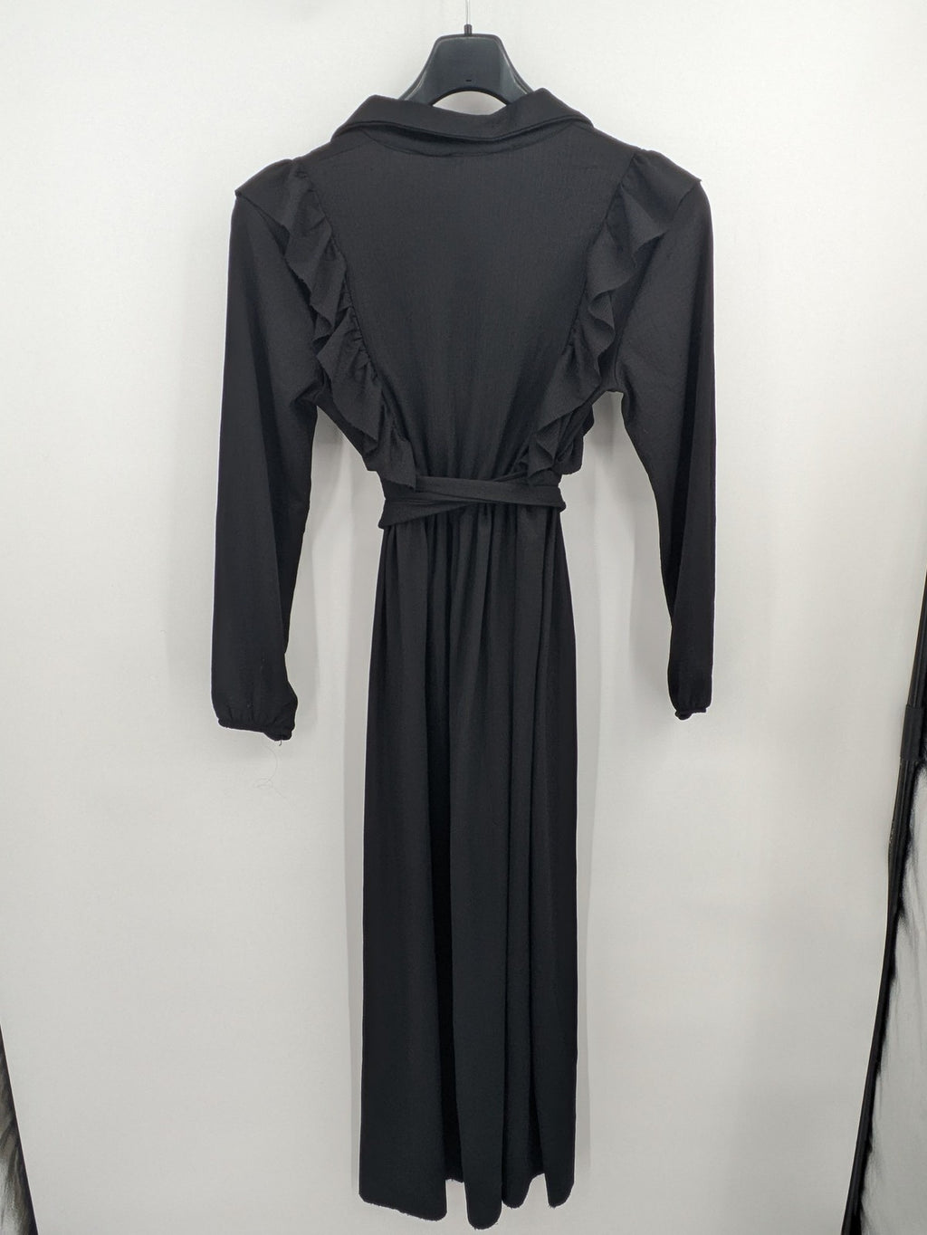 Hakke black maxi dress with ruffle details, long sleeves, and matching belt.