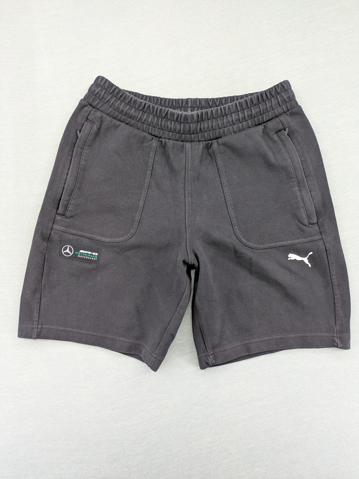 Puma grey sweatshorts featuring Mercedes AMG Petronas logo and elastic waistband.