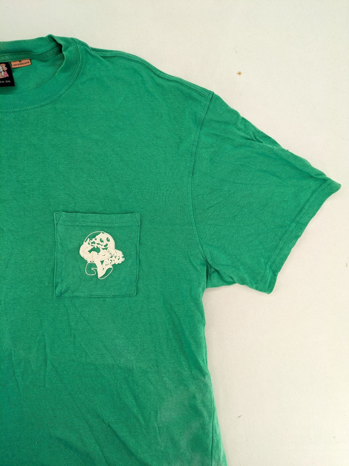 Myla green graphic t-shirt with large peace earth print and front pocket design.