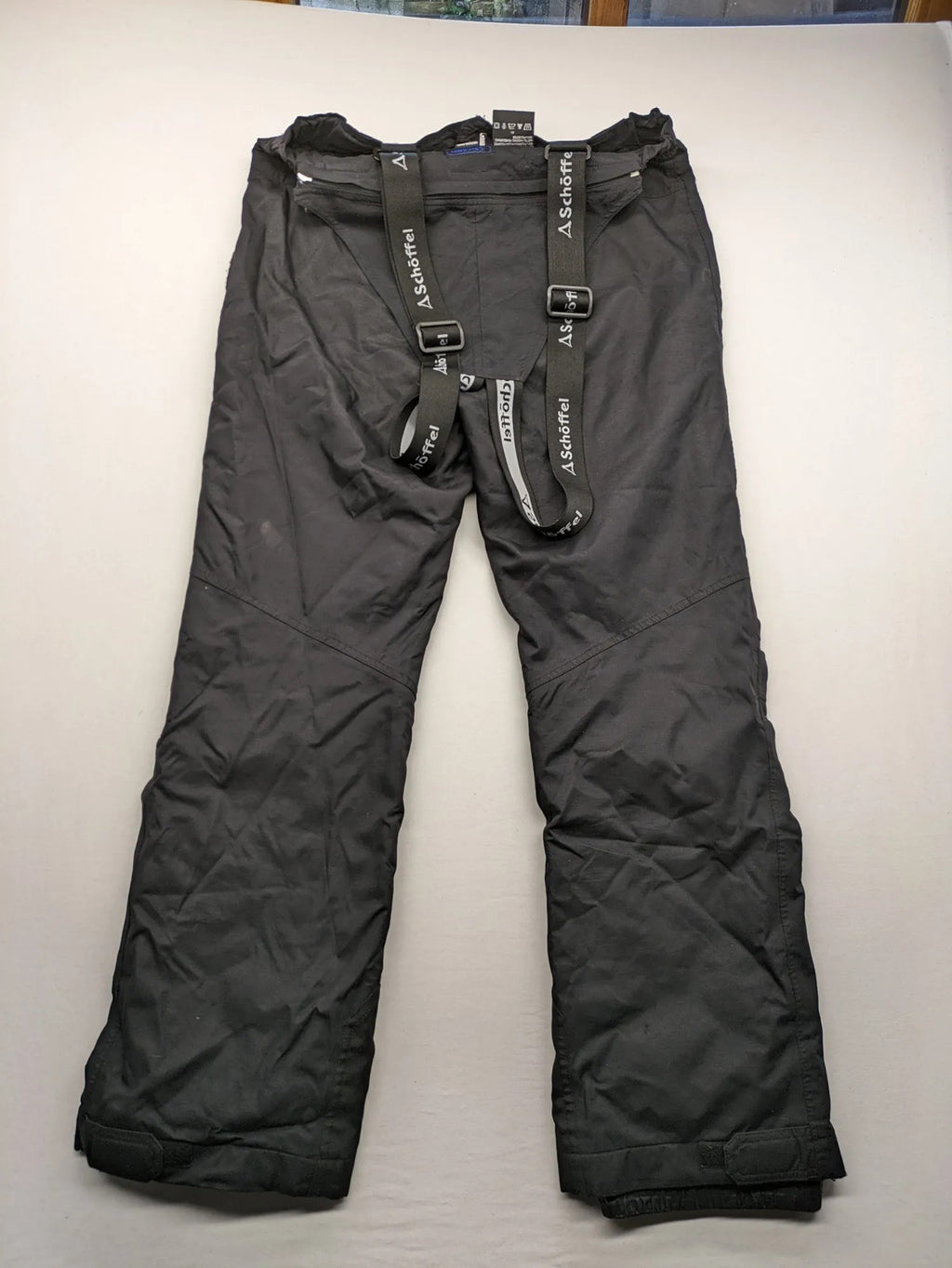Schoffel black ski pants with adjustable straps, zip pockets, and snow gaiters.