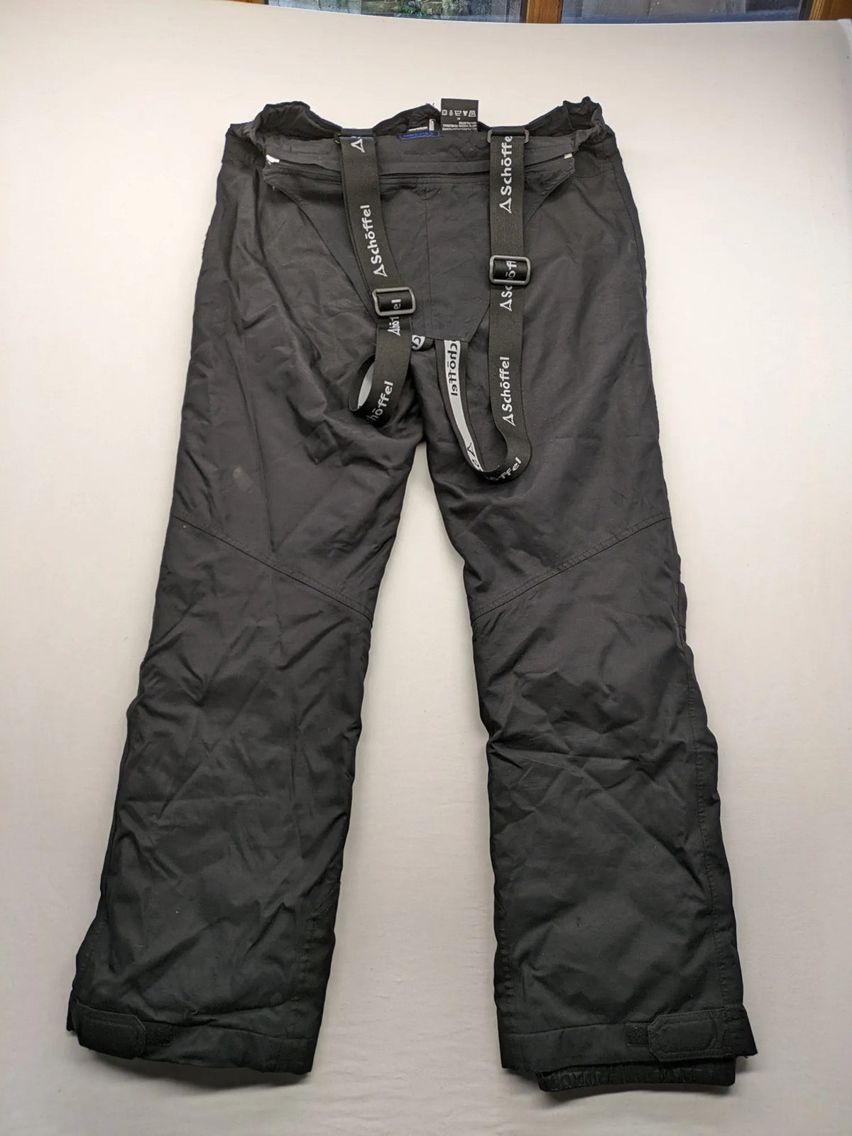 Schoffel black ski pants with adjustable straps, zip pockets, and snow gaiters.