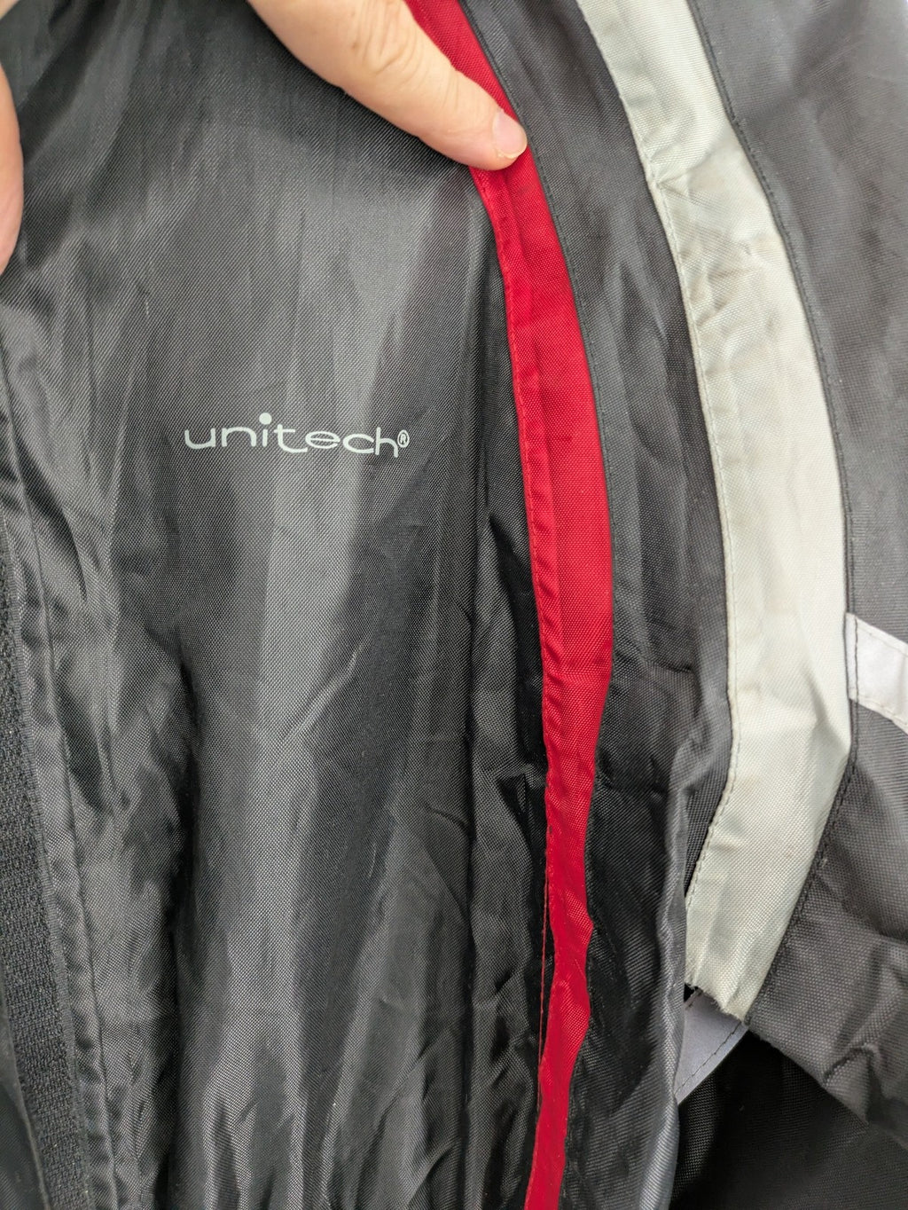 Unitech black rain suit with red reflective stripes and full zipper, size M.