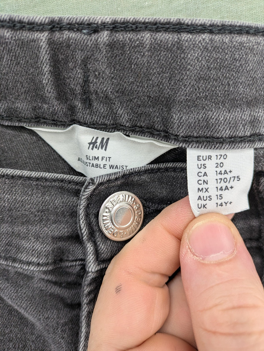H&M grey slim fit jeans with adjustable waistband and faded wash detail.