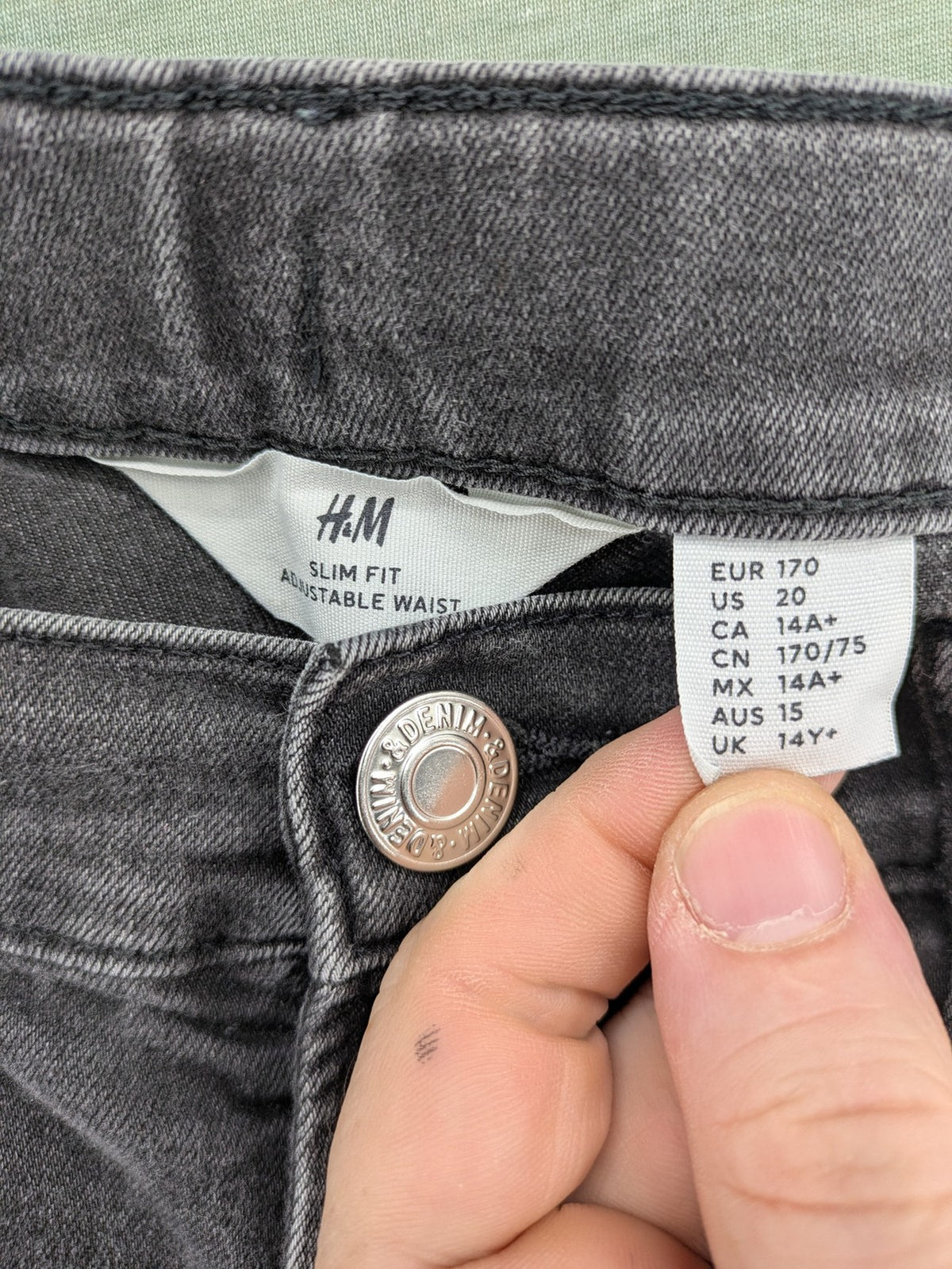 H&M grey slim fit jeans with adjustable waistband and faded wash detail.