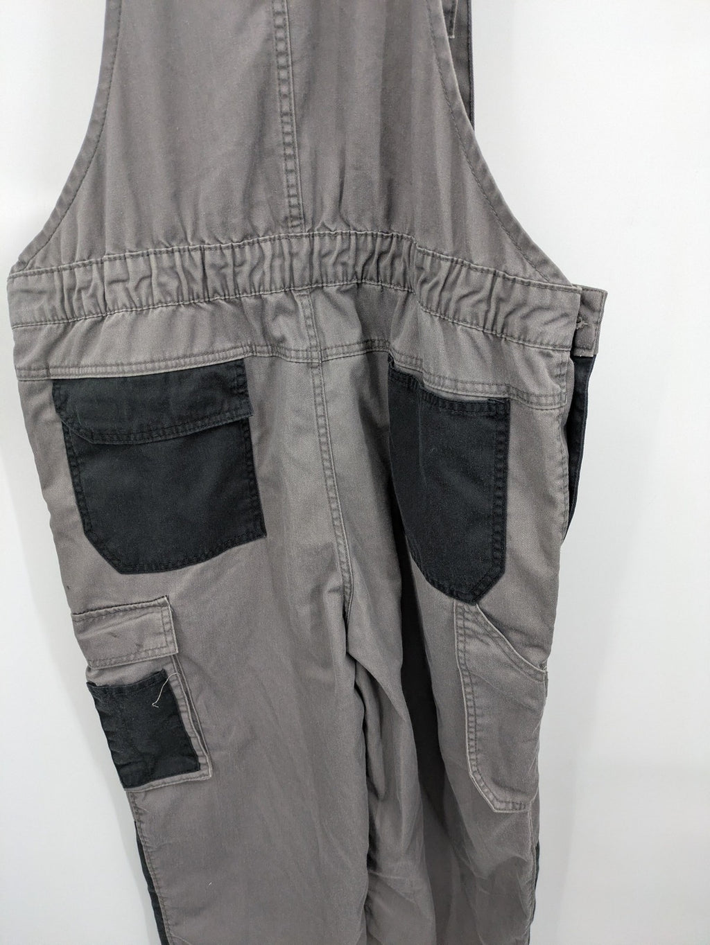 Herren Latzhose grey with black accents, multiple cargo pockets, durable polyester-cotton blend.