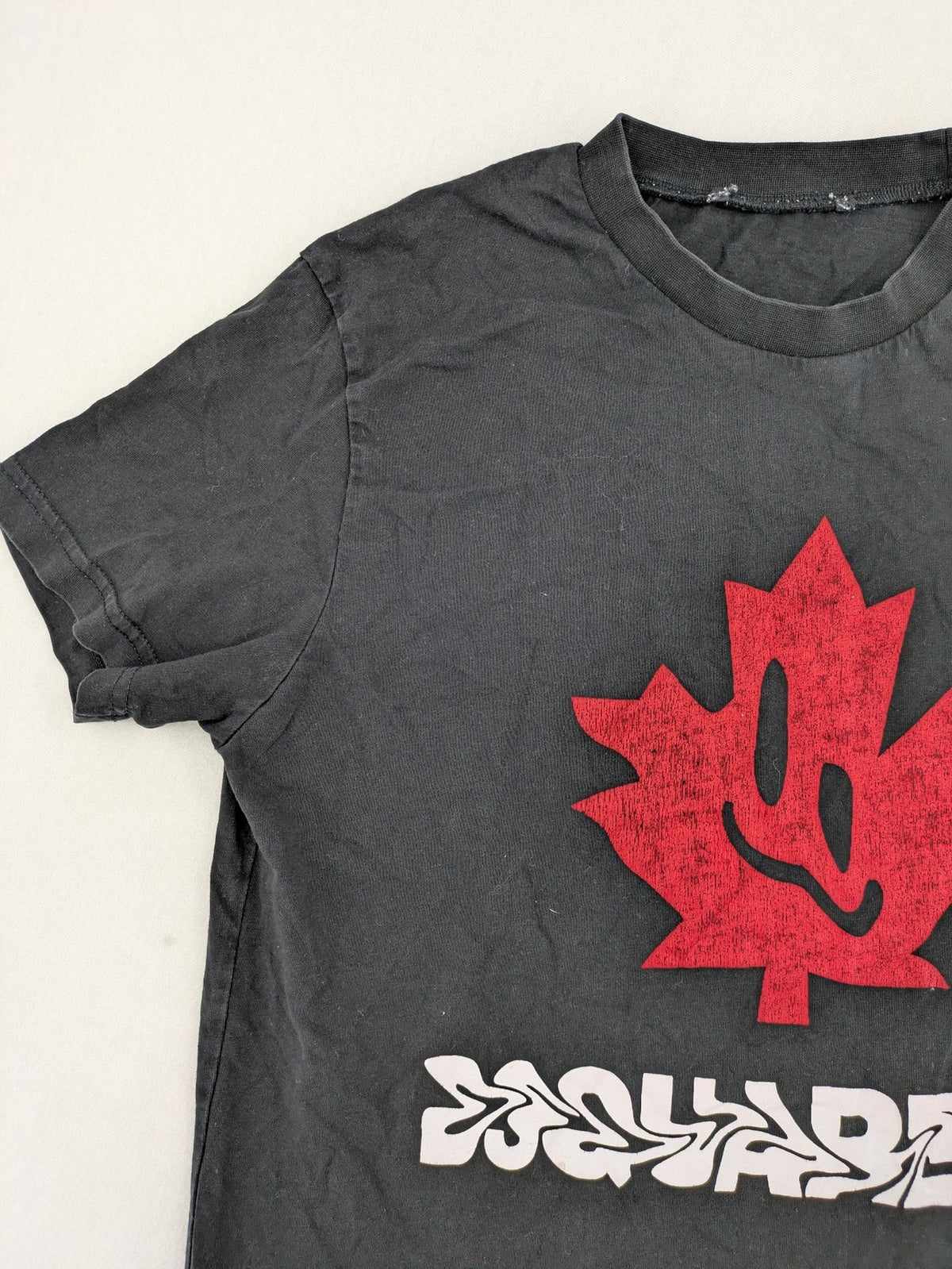 Dsquared2 grey short sleeve shirt with red maple leaf and smiley face graphic.