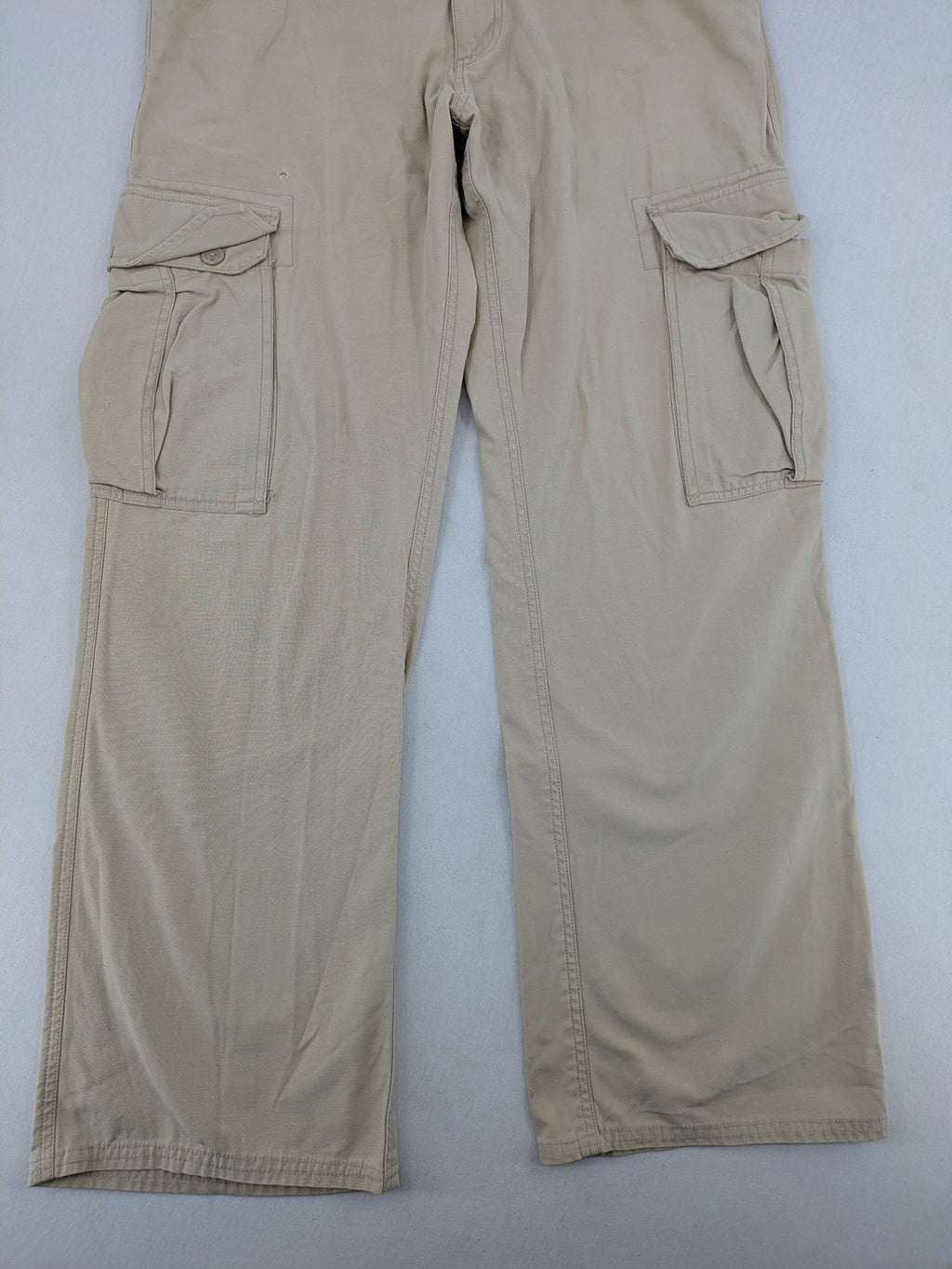 Cottonfield beige cargo pants with multiple pockets and button flaps.