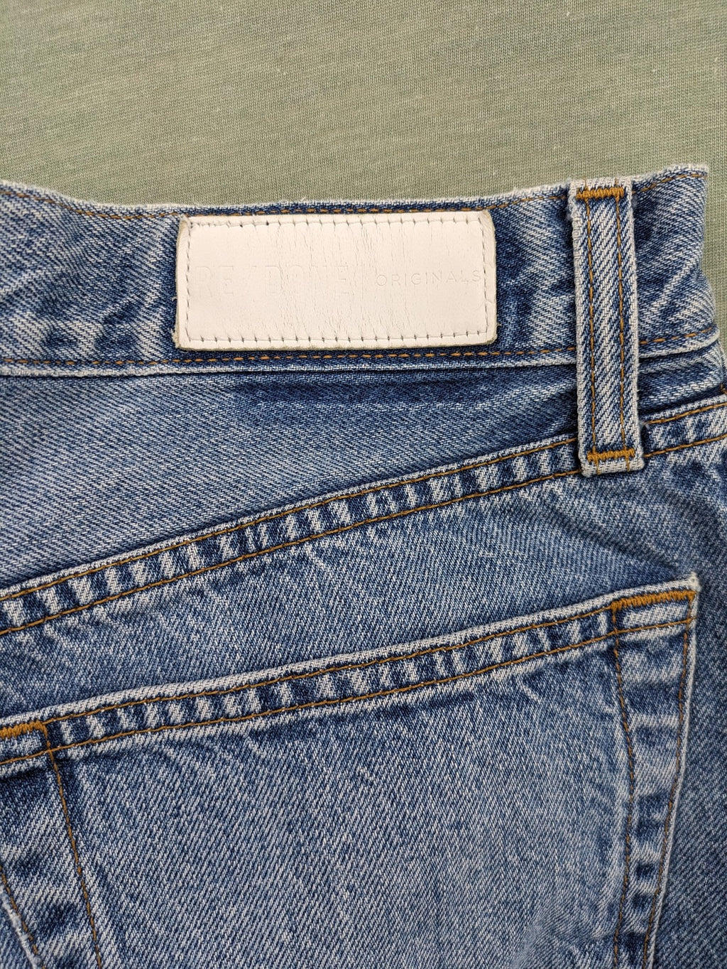 Re/Done blue straight jeans high rise with button fly and raw hem detail.