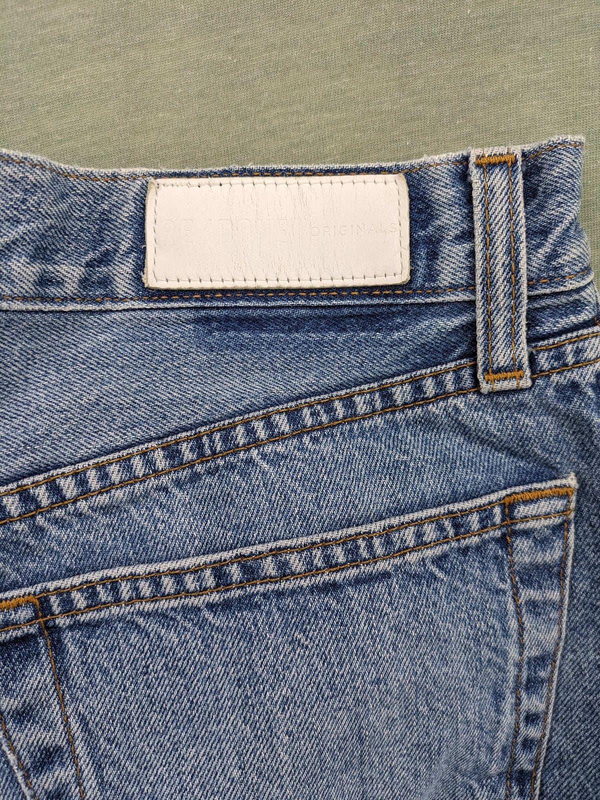 Re/Done blue straight jeans high rise with button fly and raw hem detail.
