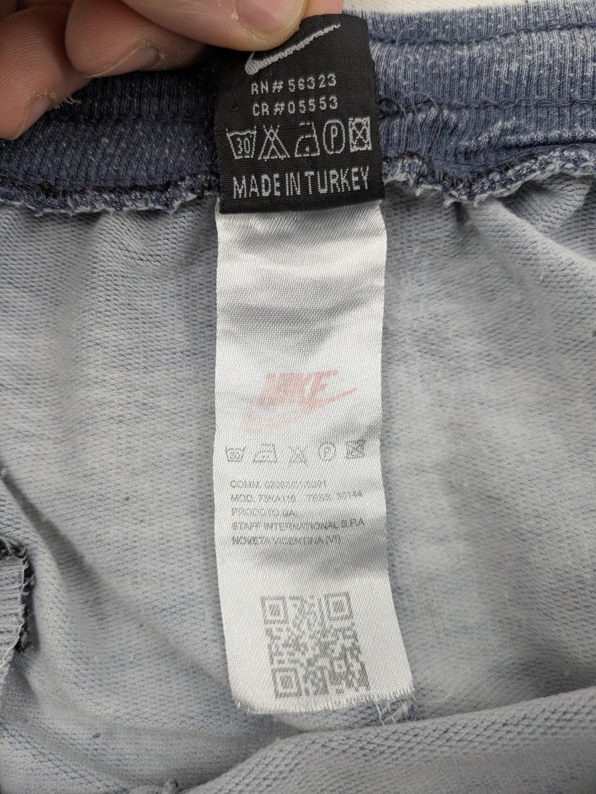 Nike grey acid wash jogger shorts with embossed logo and zip pockets.